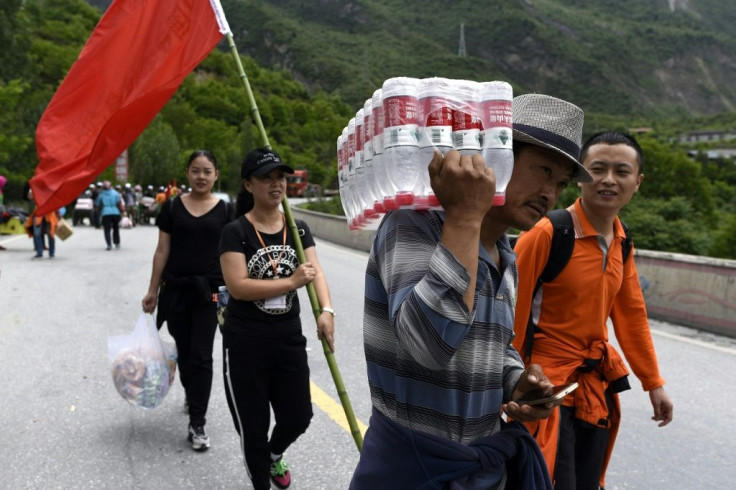 A man carries bottles Nongfu Spring water near the village of Xinmo in Maoxian county of China's Sichuan province. The brand is reported to China's most popular