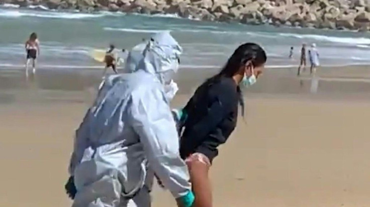 A woman who went surfing when she should have been self-isolating after testing positive for Covid-19 is arrested on a beach in San Sebastian in northern Spain