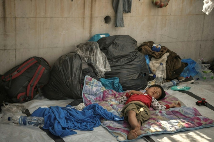 A child sleeps rough, exposed to the elements