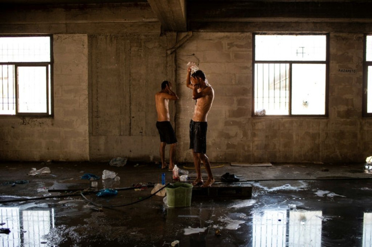 Migrants clean themselves inside an abandoned building