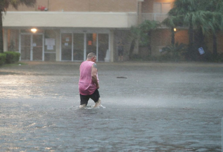 A man walks though a flooded parking lot in Gulf Shores, Alabama