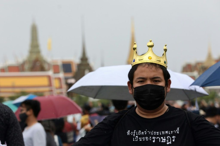 A pro-democracy protester wears a fake crown and a shirt that reads 'please realise this country belongs to the people' during the anti-government rally in Bangkok