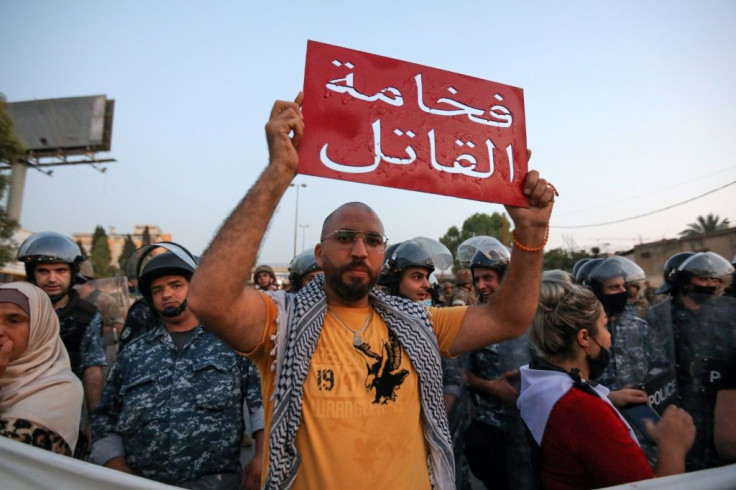 A Lebanese protester held a sign reading in Arabic "Your highness the murderer", referring to the country's president, during a demonstration earlier this month against the lack of progress in a probe by authorities the Beirut port explosion