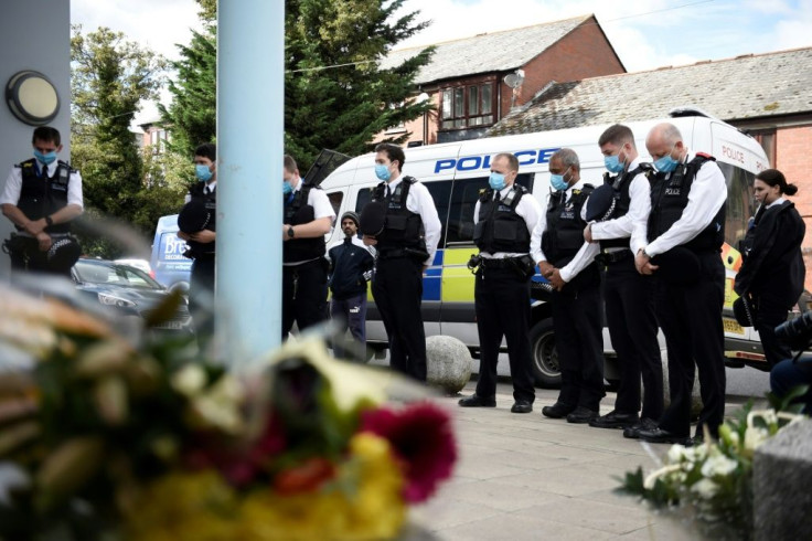 British police officers stand in a minute's silence in the memory of Sergeant Matiu Ratana, who was shot dead on Friday