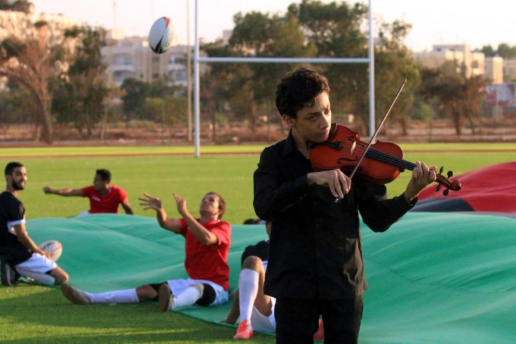 A Libyan youth plays the violin at the opening of the first rugby field at the University of Benghazi, which was built as part of the United Nations Office Development Programme