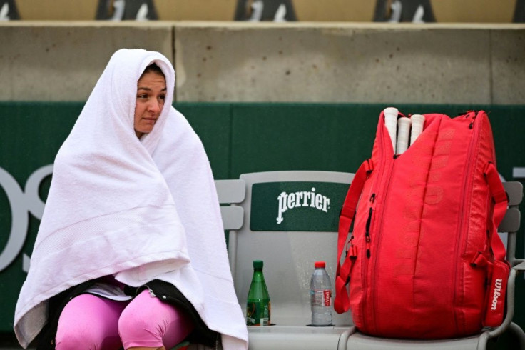 Cover-up: Russia's Margarita Gasparyan waits for the rain to stop