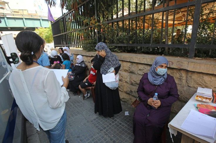 Women wait their turn outside a mobile clinic supported by UNFPA in Beirut's Basta neighbourhood