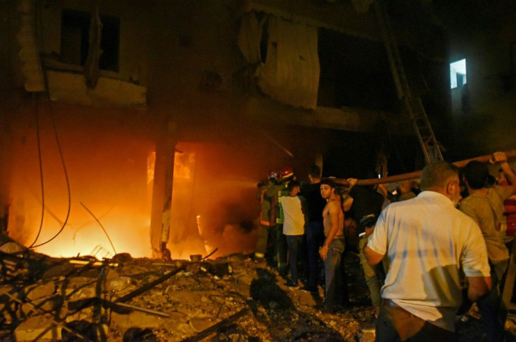 Firefighters extinguish a fire at a building after a fuel tank exploded in Beirut's Tariq al-Jdide neighbourhood