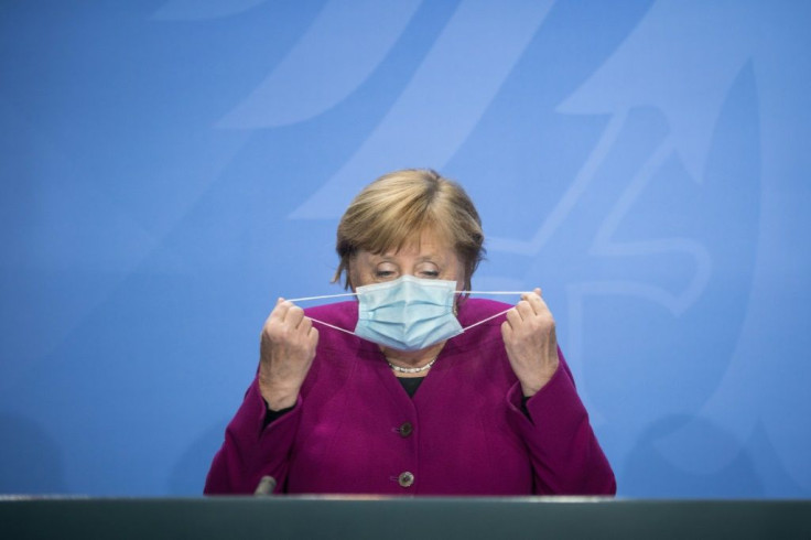 German Chancellor Angela Merkel takes her face mask off for a press conference after a meeting with the leaders of Germany's federal states on the coronavirus situation at the Chancellery in Berlin on Wednesday.