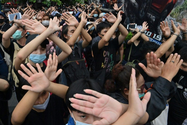 Pro-democracy protesters learn hand gestures and signs to communicate and warn each other in Bangkok