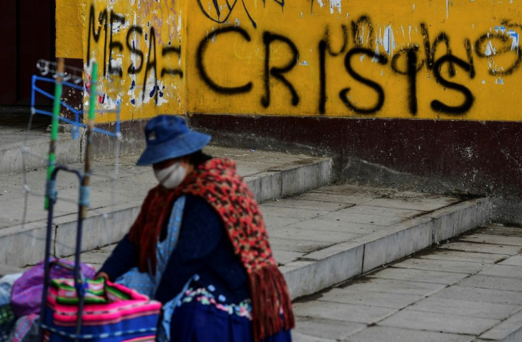 A woman is seen near a wall with graffiti against presidential candidate Carlos Mesa, in El Alto