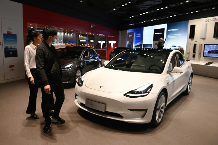 A man looks at a Tesla Model 3 in a Tesla showroom in Beijing on October 21; the electric car giant reported a doubling of profits on robust sales growth