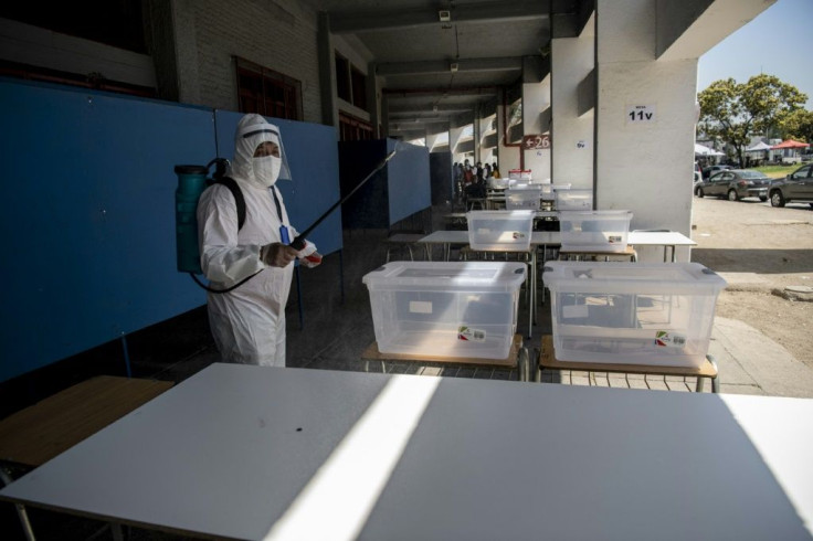 A worker disinfects a polling station in Santiago on the eve of Chile's constitutional referendum, which is being held as the country battles the coronavirus epidemic