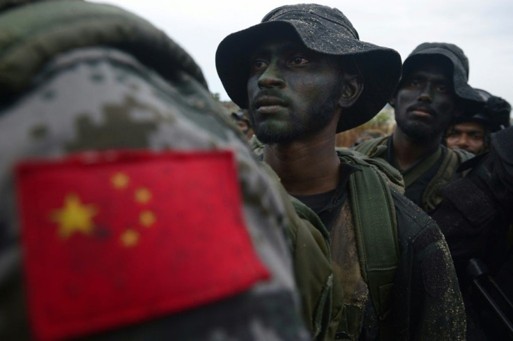 A Chinese soldier stands with Sri Lankan military personnel during a training exercise on the eastern coast of Trincomalee in September 2019