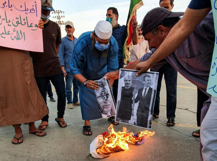 Demonstrators set fire to pictures of French President Emmanuel Macron in Libya