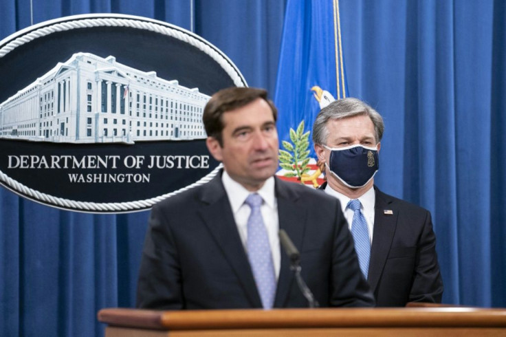 Assistant Attorney General John Demers (L) and FBI Director Christopher Wray announced the arrests of five Chinese agents for their roles in an operation targeting Chinese government opponents in the US