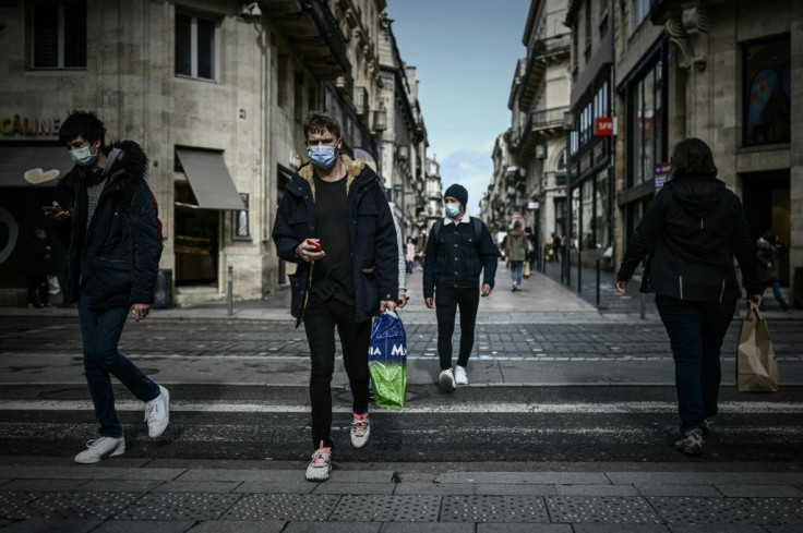 Pedestrians cross a street in the mandatory face mask zone to limit Covid-19 infections in Bordeaux