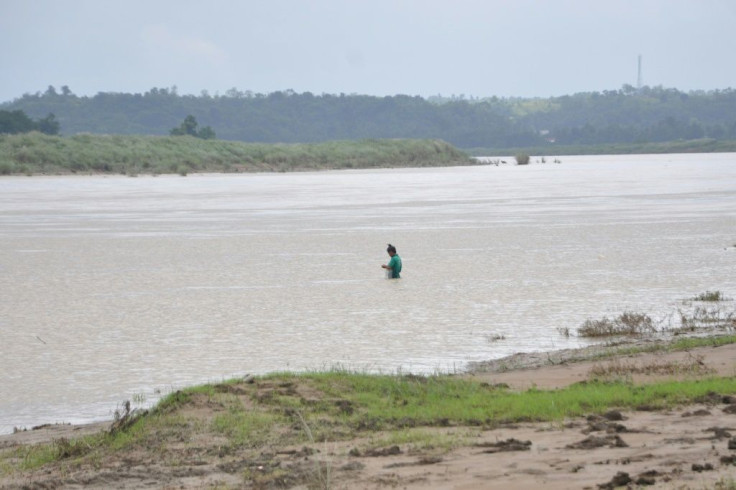 A man fishes in a swollen river caused by heavy rains north of Manila, ahead of Typhoon Goni's landfall in the Philippines