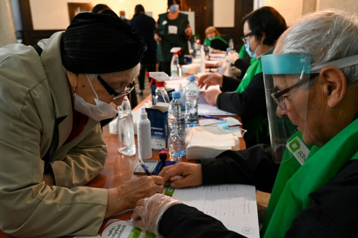 Voter protection: A woman receives her ballot form at a polling station in Tbilisi on Saturday