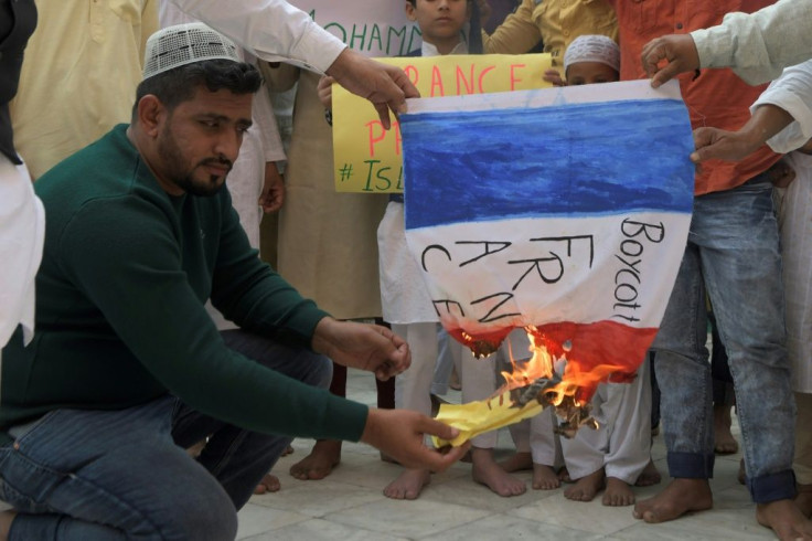 Muslim devotees burn a French national flag during a demonstration to protest against French President Emmanuel Macron in India.