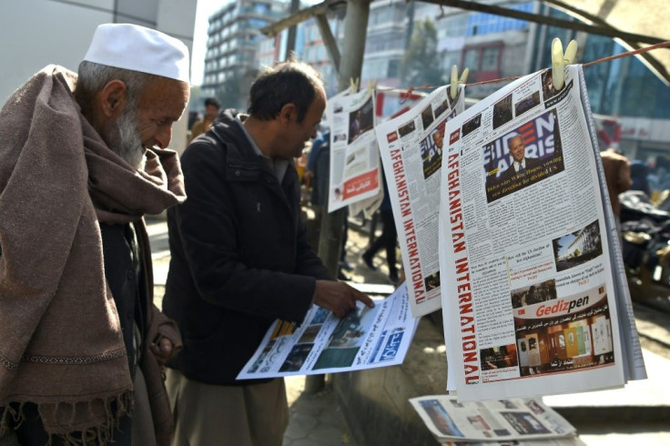 A man reads a local newspaper showing a photograph of newly elected US President Joe Biden, in Kabul on November 8, 2020, where some residents hope the President-elect may slow down the US withdrawal from Afghanistan