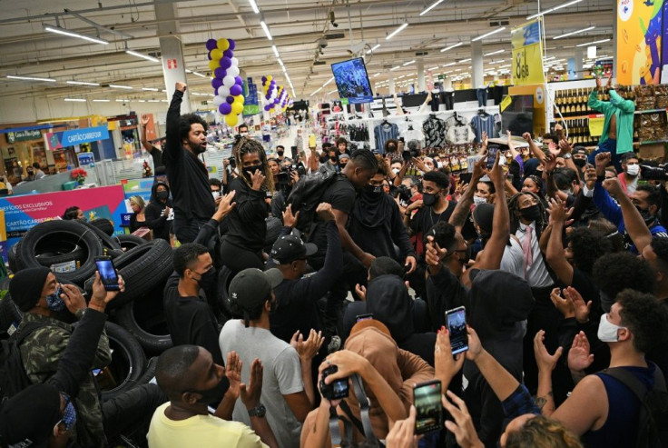 Demonstrators make a barrier out of car tires as they take part in a protest inside the Carrefour supermarket in Rio de Janeiro, Brazil, on November 20, 2020, against the death of a black man beaten by security guards at another store from the chain