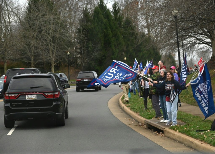 Supporters of US president Donald Trump cheer as he passes in the motorcade after golfing in Sterling, Virginia on November 21, 2020