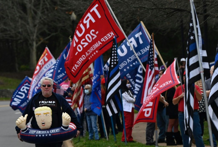 Supporters of US President Donald Trump wait for the motorcade after the president finished golfing in Sterling, Virginia on November 21, 2020