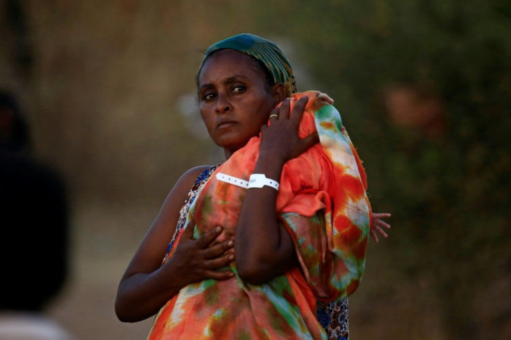 An Ethiopian mother carries her baby in the Um Raquba refugee camp in eastern Sudan, where she fled to from fighting in her homeland of Tigray; healthcare facilities are severely limited