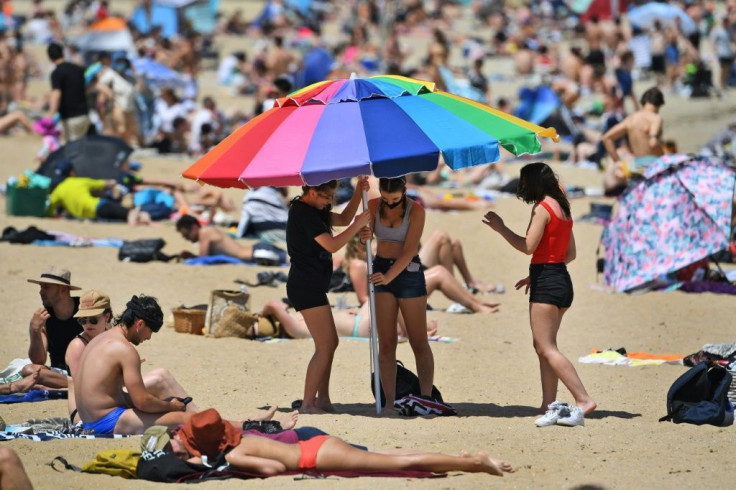 People enjoy the warm weather on Melbourne's St Kilda Beach after the Australian city began to lift virus restrictions