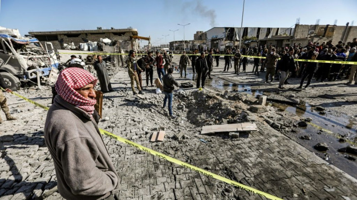 People inspect the scene of a car bomb in the Turkish-controlled town of Al-Bab in the north of Syria's Aleppo province