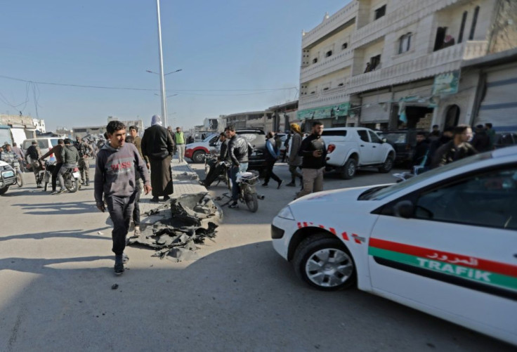 A man walks towards a Turkish-backed local police vehicle at the scene of a car bomb in the Turkish-controlled town of Al-Bab in the north of Syria's Aleppo province