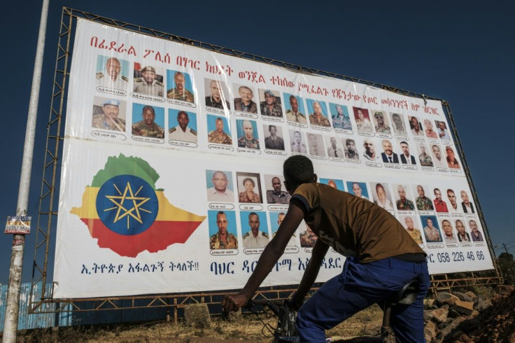 A youngster in Bahir Dar, the capital of Amhara region, stands in front of a wanted sign showing members of the Tigray Peopleâs Liberation Front (TPLF), who are being sought for alleged treason