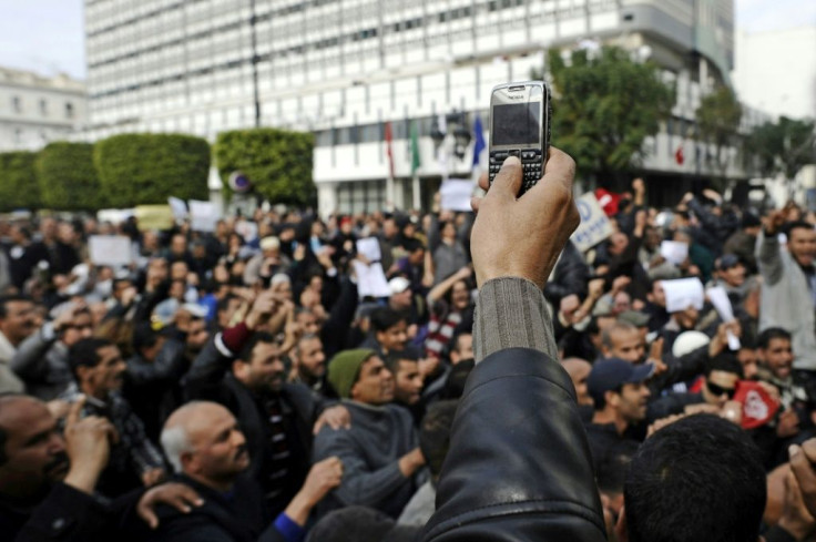 A protester records with his mobile phone a demonstration in central Tunis on January 19, 2011