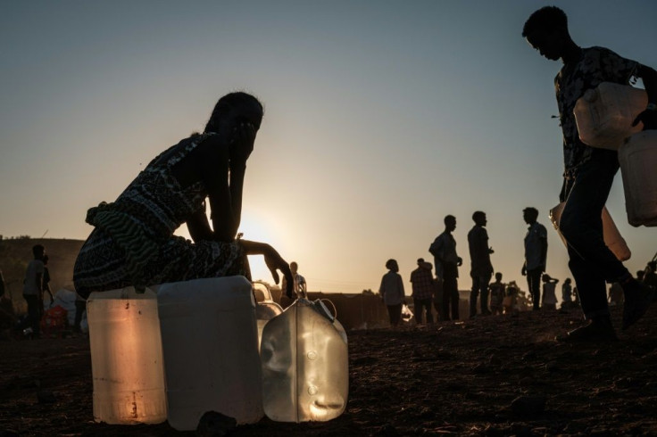 A refugee sits on a water container at the Um Raquba camp in eastern Sudan