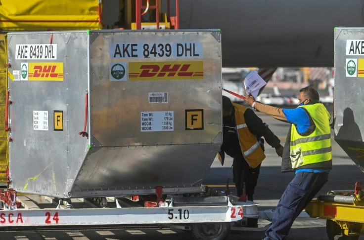 Workers at the Mexico City airport unload containers from an airplane carrying the second shipment of the Pfizer/BioNTech COVID-19 vaccine for the country