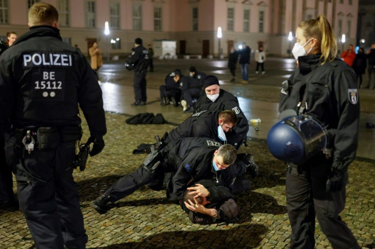 Police arrest a man at Bebelplatz square after they tried to disperse a crowd of revellers following celebrations at the Brandenburg Gate in Berlin, early on January 1, 2021