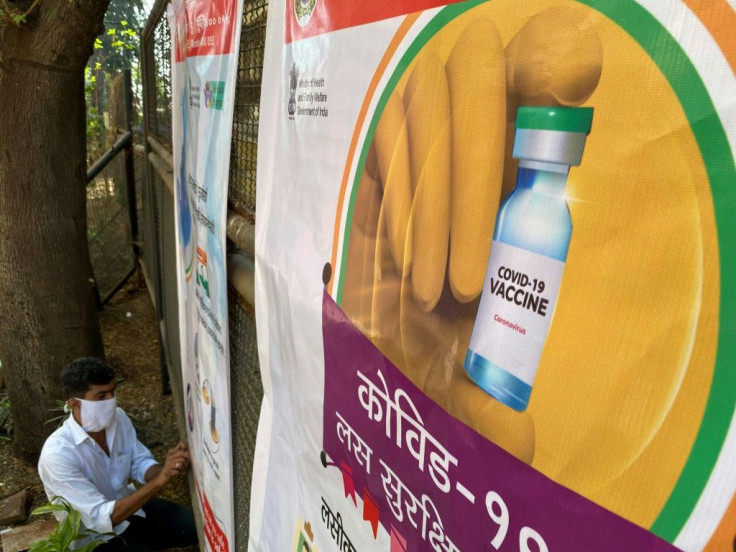 A worker sets up a poster at a coronavirus vaccination centre in Mumbai on January 15, 2021, with the Indian government aiming to inoculate around 300 million people by July