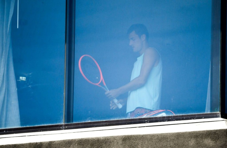 Australian tennis player Bernard Tomic exercises in his hotel room in Melbourne on Sunday as players undergo quarantine ahead of the Australian Open