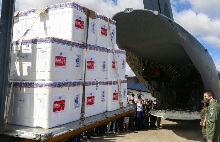 Brazilian soldiers load CoronaVac vaccine doses into a military plane at Guarulhos airport in Sao Paulo for distribution across the country on January 18, 2021
