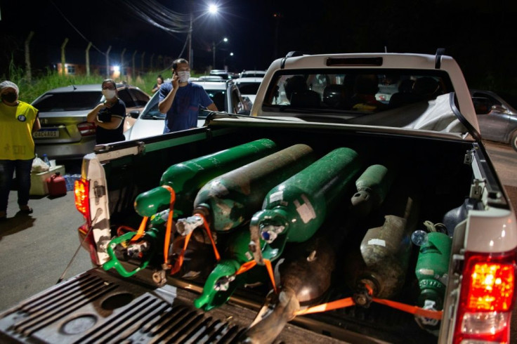 A pick-up truck carries oxygen tanks in Manaus