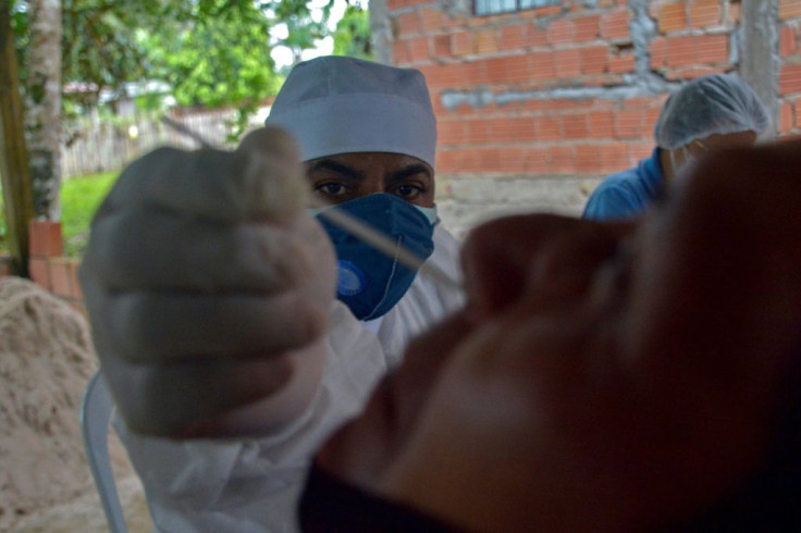 A health worker collects a swab sample from a resident to perform a COVID-19 test provided by the International Organization for Migration (IOM) in the riverside community of Bela Vista do Jaraqui in Amazonas state, Brazil, on January 18, 2021