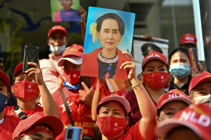 Myanmar migrants hold up portraits of Aung San Suu Kyi as they take part in a demonstration outside the Myanmar embassy in Bangkok following a military coup in which the democratic leader was arrested