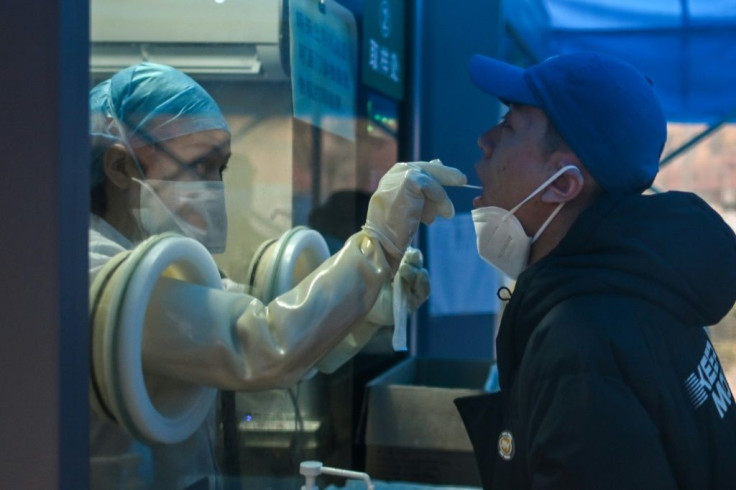 A health worker takes a swab sample from a resident in the Chinese city of Wuhan, which WHO experts visited in a attempt to discover the orgins of the Covid-19 virus
