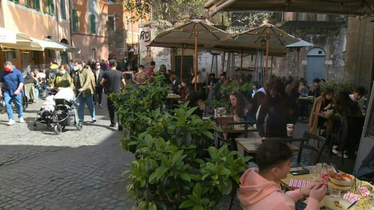 Italians eat at restaurants and walk the streets of Trastevere in Rome on the eve of a partial lockdown. Schools, restaurants, shops and museums will close across most of the country