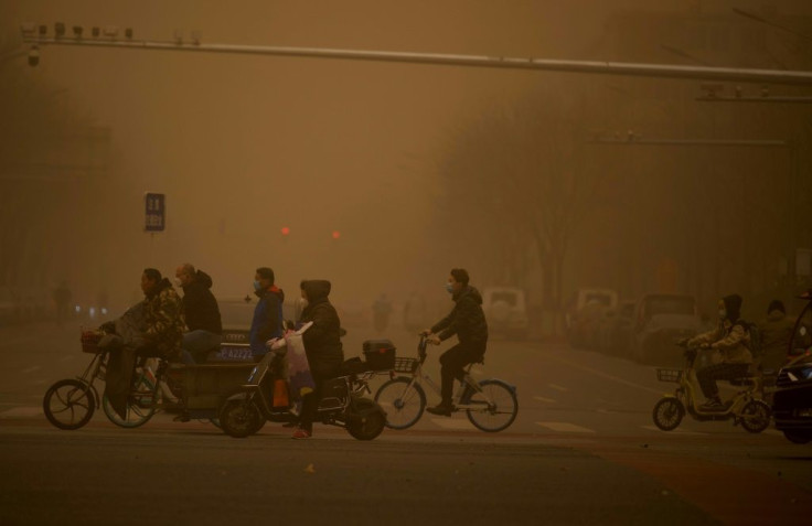 Beijing residents used goggles, masks and hairnets to protect themselves from the choking dust and sand