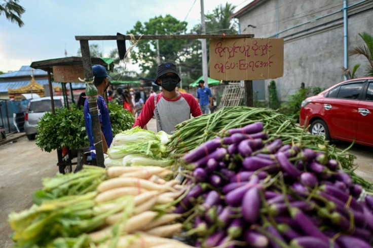 People push carts with vegetables for distribution during a food drive in Yangon