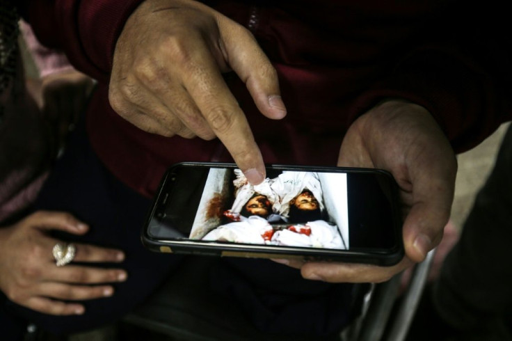 Muhammad Abu Jazar, 34, shows his daughter Maisam, 12, a picture of his children who were killed during the 2014 Gaza war