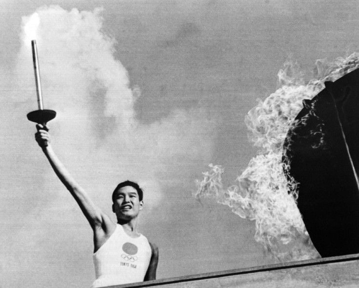 In a symbol of Japanese pacifism, athlete Yoshinori Sakai -- born the day the Hiroshima bomb was dropped -- carries the Olympic torch at the opening ceremony of the 1964 Tokyo Games - AFP