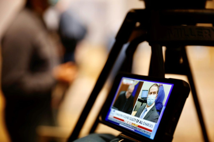 A journalist watches their mobile phone showing Derek Chauvin as the guilty verdicts in his trial over the death of George Floyd are announced